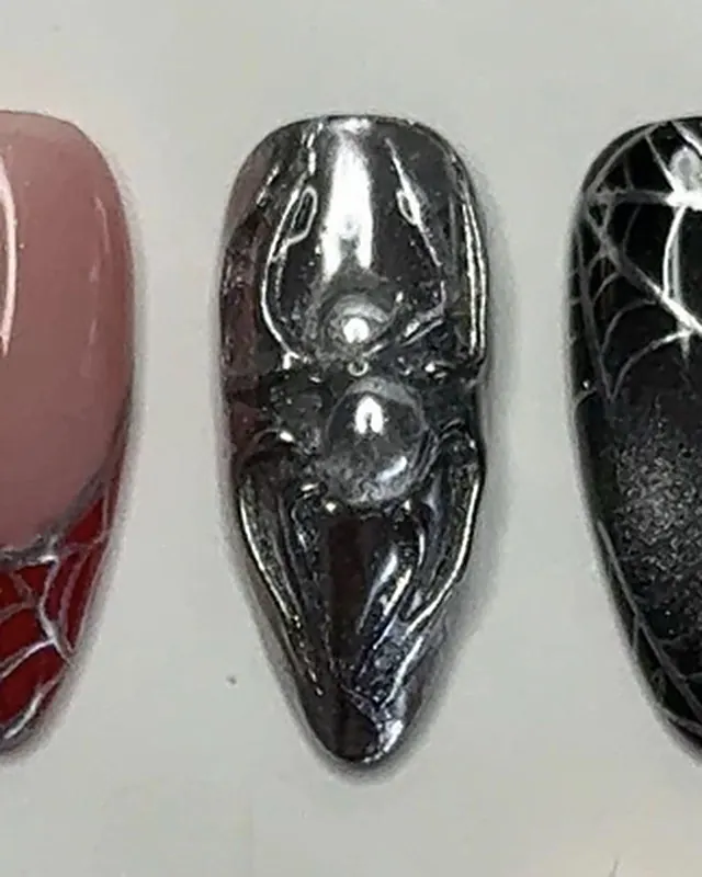 Ongle amande chromé argent, une araignée en relief au centre.