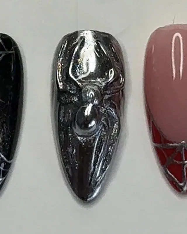 Un deuxième ongle chromé à araignée, entre une toile noire et une french rouge.