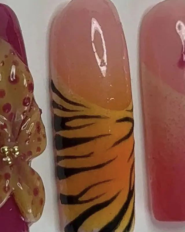 Le même motif tigre, entre une orchidée en relief et un ongle rose à pois.