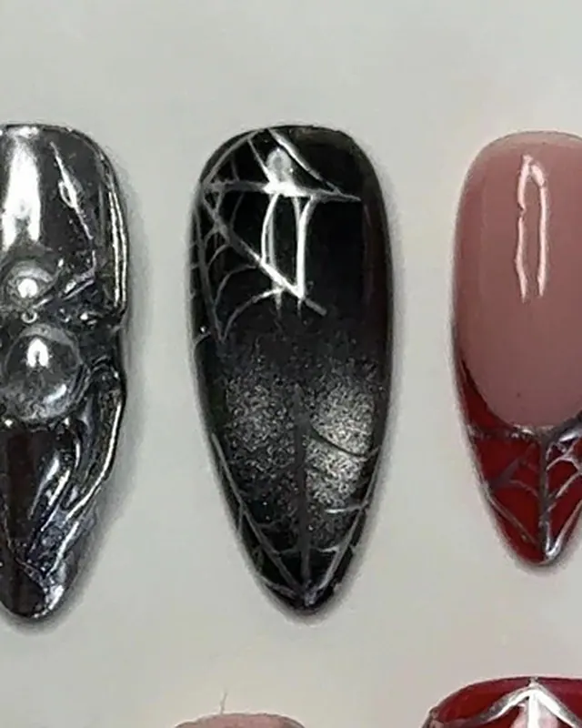 Un autre ongle noir à toile argentée, entre un ongle chromé et une french rouge.